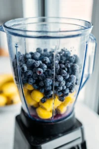 Combine frozen blueberries, fresh lemon juice, sugar, and cold water in a blender