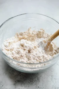 Combine lukewarm water, sugar, and cinnamon in a bowl, then mix well and gradually add flour to form a smooth dough.
