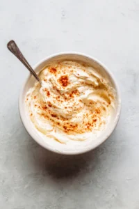 Combine mayonnaise, sour cream, lime juice, and Tajin seasoning in a mixing bowl