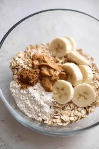Combine oats, protein powder, peanut butter, honey, mashed banana, vanilla extract, and baking powder in a mixing bowl