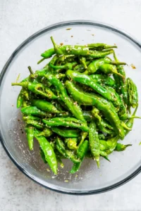 Combine shishito peppers with olive oil and sea salt
