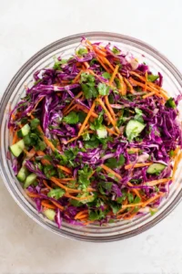 Combine shredded cabbage, carrots, cucumber, and cilantro