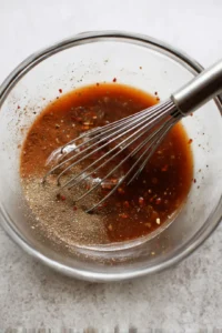 Combine soy sauce, brown sugar, garlic powder, onion powder, black pepper, red pepper flakes, and liquid smoke in a mixing bowl and stir until dissolved.