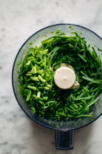 Combine the chopped scallions and wild garlic stems in a food processor and pulse until finely chopped
