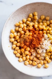 Combine the drained chickpeas, olive oil, garlic powder, smoked paprika, and cumin in a bowl
