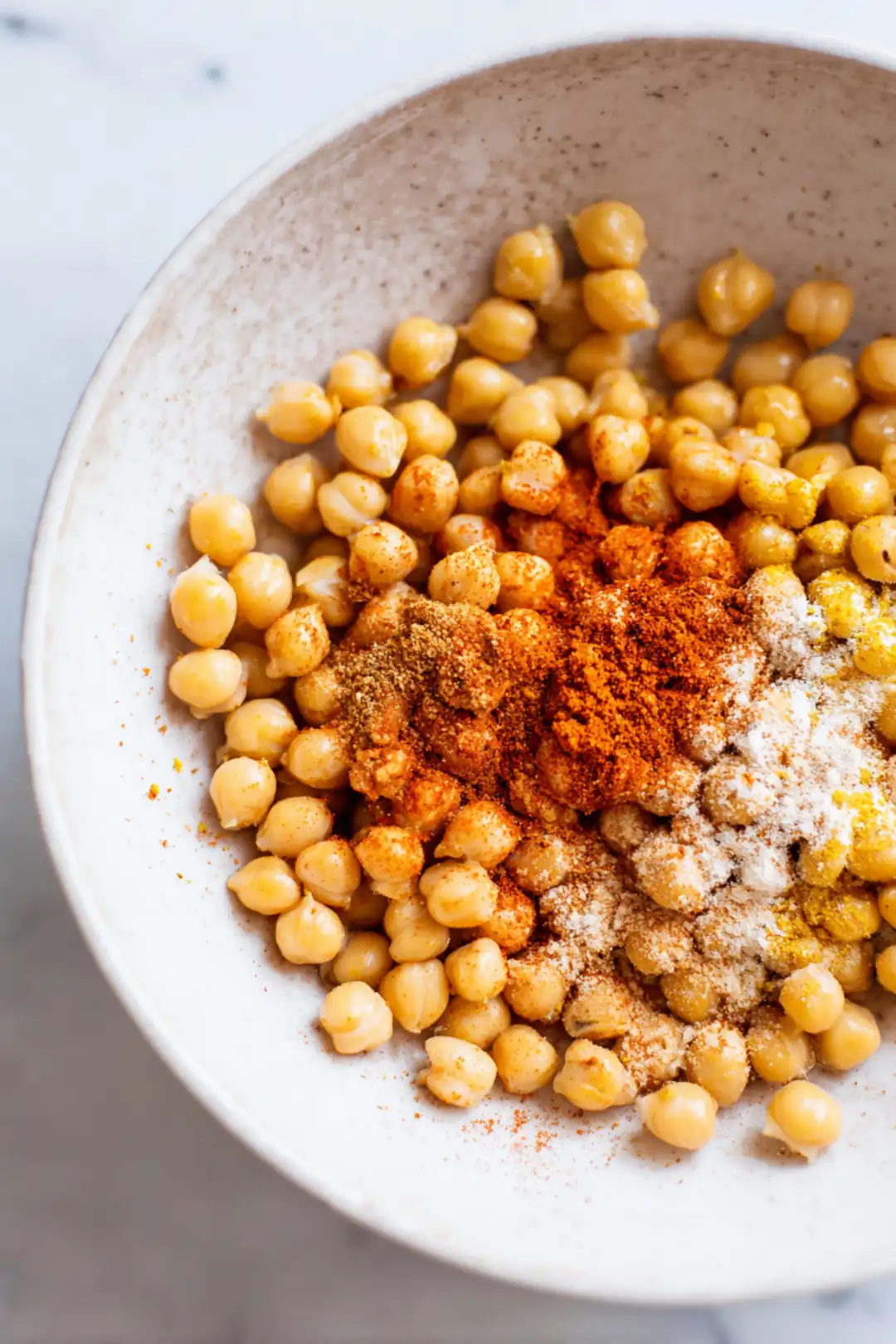 Combine the drained chickpeas, olive oil, garlic powder, smoked paprika, and cumin in a bowl