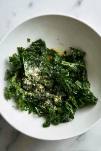 Combine torn kale with olive oil, garlic powder, salt, and black pepper