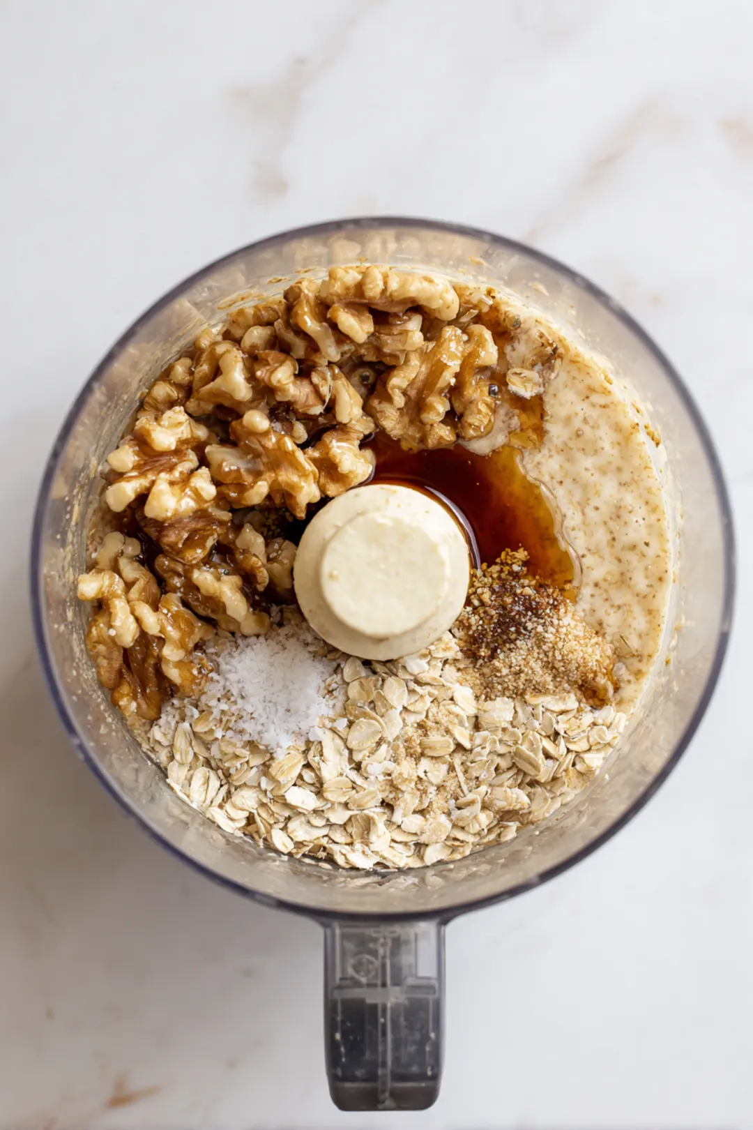 Combine walnuts, rolled oats, honey, vanilla extract, and salt in food processor