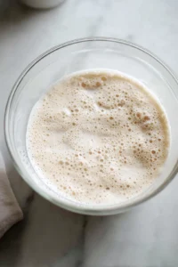 Combine warm water, sugar, and yeast in a bowl and let it sit until frothy
