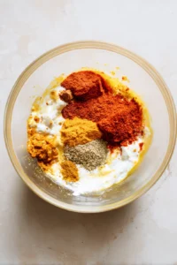 Combine yogurt, ginger garlic paste, red chili powder, turmeric powder, garam masala, lemon juice, and salt to create the marinade