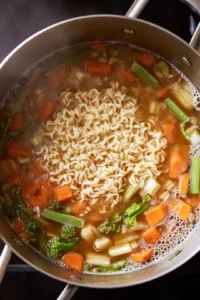 Cook instant ramen noodles in boiling vegetable broth for 3 minutes until tender
