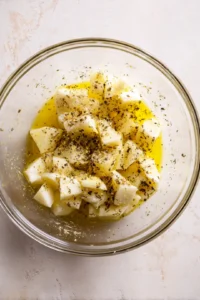 Cut bao buns into bite-sized crouton shapes and toss with olive oil, garlic powder, salt, and pepper