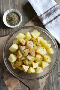 Cut the Honey Gold Potatoes into bite-sized pieces and toss with olive oil, salt, pepper, garlic powder, and paprika.