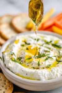 Drizzle hot honey over whipped feta and add fresh herbs