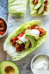 Fill a blanched cabbage leaf with the bean-tomato mixture and top with avocado slices and sour cream
