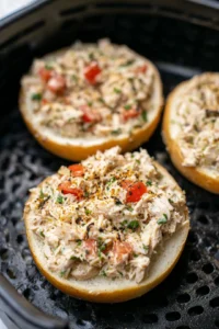 Fill each bagel half with the tuna mixture and place them in the air fryer basket.