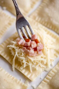Fold over the dough triangles after filling with ham and cheese