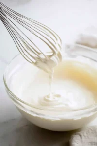 Froth heavy cream and vanilla syrup until soft peaks form