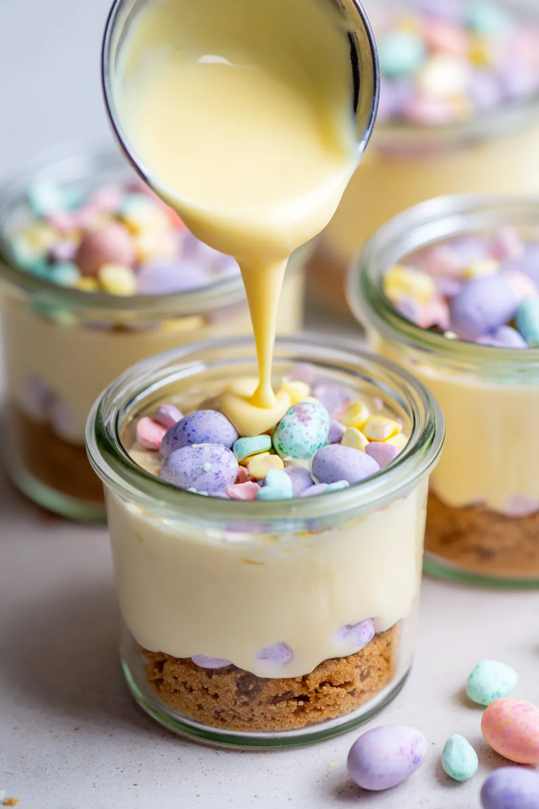 Layer the cheesecake filling over the biscuit base in each jar and top with chopped Cadbury Mini Eggs