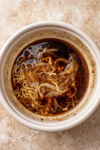 Mix beef broth with caramelized onions and ramen noodles