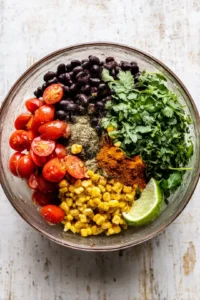 Mix black beans, corn, cherry tomatoes, cilantro, lime juice, cumin, and paprika in a bowl