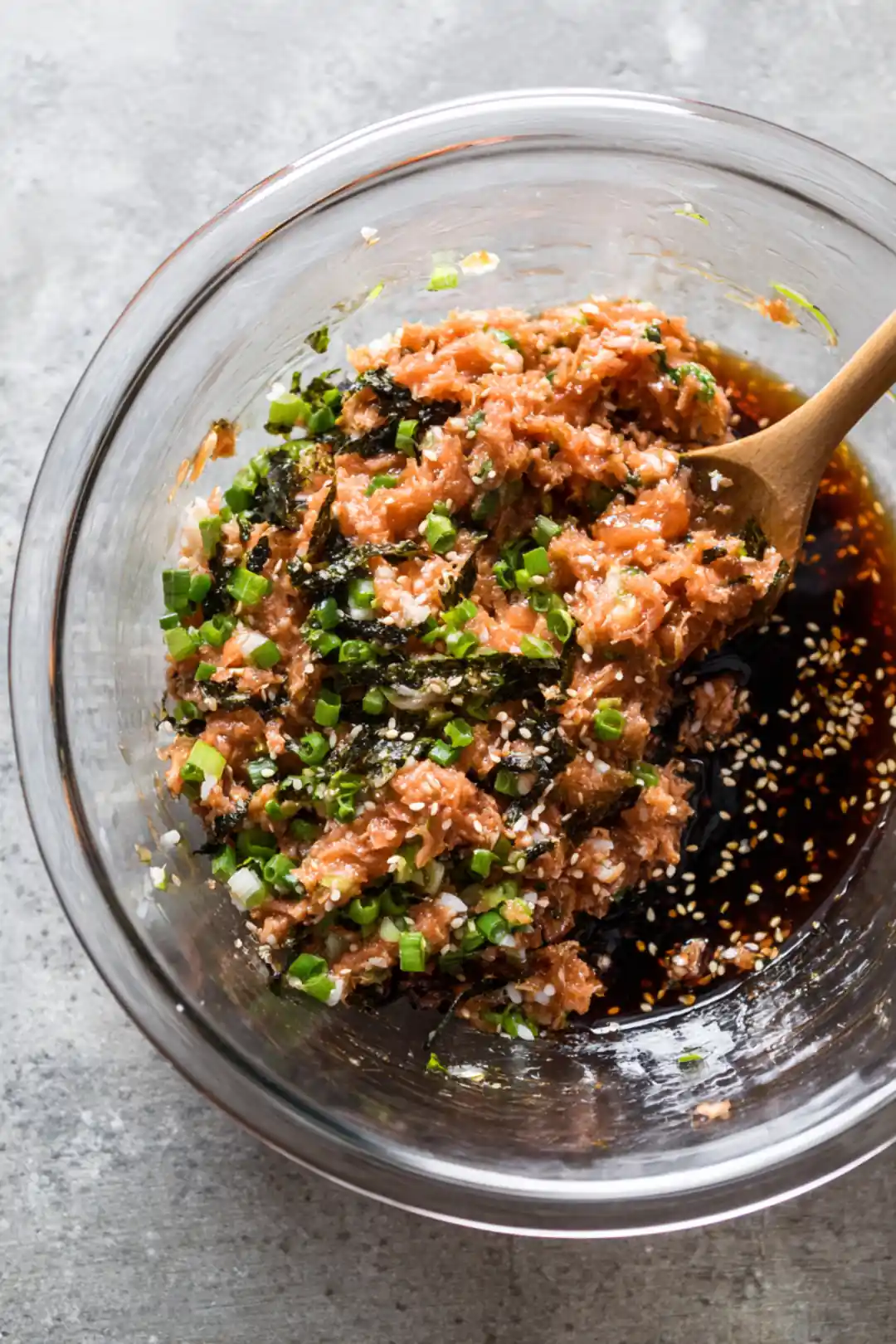 Mix cooked sushi rice with spicy tuna, green onions, soy sauce, and sesame oil until well combined