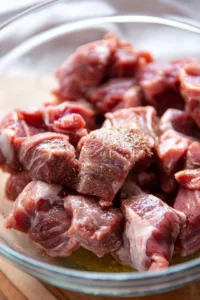 Mix lamb chunks with olive oil, salt, and pepper until evenly coated