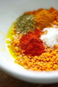 mix olive oil, salt, paprika, garlic powder, and cumin with lentils