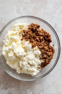 Mix together ricotta cheese, cooked ground beef, and mozzarella cheese