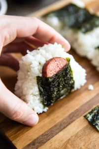 Mold rice around a piece of Spam to form a tiny musubi bite