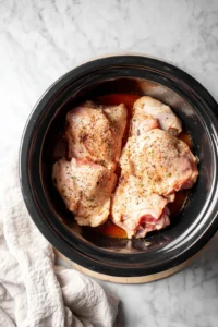 Place the chicken thighs in the slow cooker and season with salt and pepper. Pour the sauce mixture over the chicken, ensuring it is well coated.