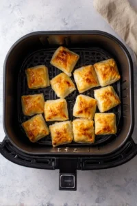 Place the pastry squares in the air fryer basket in a single layer and cook for 10-12 minutes until golden brown and crispy.