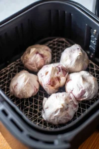Place the wrapped garlic in the air fryer basket and air fry for 25 minutes or until the cloves are golden brown and soft