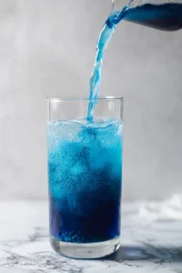 Pour butterfly pea flower tea to create the base and add vodka mixture slowly