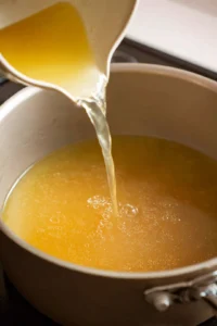 Pour chicken broth into the pot and bring to a gentle simmer