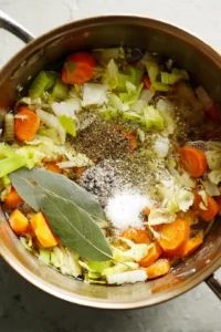 Pour in the water and add the salt, black pepper, and bay leaf. Bring to a boil, reduce the heat and let it simmer for 60 minutes. Strain the broth before serving.