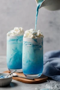 Pour the blue matcha mixture into two glasses and top with whipped vanilla cold foam