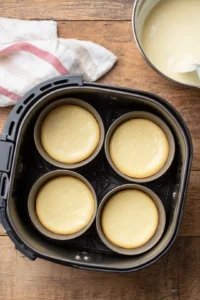 Pour the custard mixture into ramekins, filling them about 3/4 full. Place the ramekins in the air fryer basket, ensuring they don't touch each other.