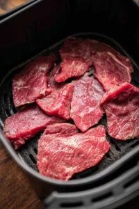 Preheat the air fryer to 160 degrees Fahrenheit and dehydrate beef slices for jerky