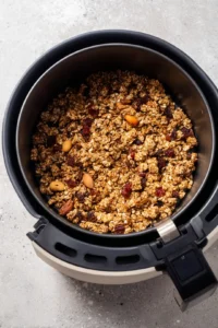 Preheat the air fryer to 350 degrees Fahrenheit and spread the granola mixture evenly in the air fryer basket