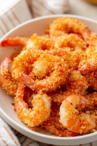 Preheat the air fryer to 400 degrees Fahrenheit and coat shrimp in breadcrumbs