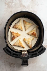 Preheat your air fryer to 350 degrees Fahrenheit and prepare croissant dough into triangles