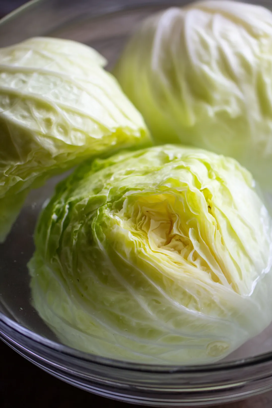 Prepare cabbage leaves by peeling them off the head and soaking them in cold water to crisp up