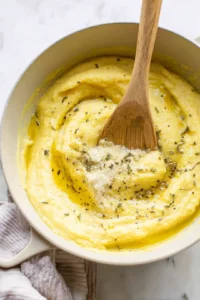 Remove polenta from the heat and stir in olive oil, garlic powder, parmesan cheese, and herbs until well combined