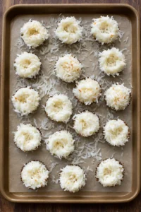 Shape the coconut mixture into small nests on the prepared baking sheet