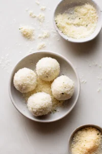 Shape the cooled rice mixture into balls and roll them in breadcrumbs to coat evenly.