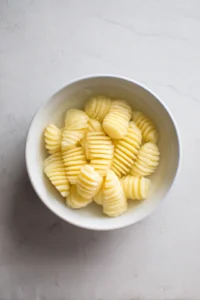 Slice potatoes accordion-style and soak in cold water for 10 minutes