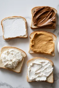 Spread marshmallow fluff on two slices of bread and the peanut butter and Nutella on the remaining slices
