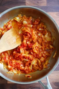 Stir in grated Parmesan cheese, kimchi, and shredded cabbage until well incorporated
