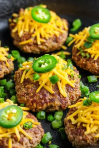 Top each patty with diced jalapeños and shredded cheddar cheese